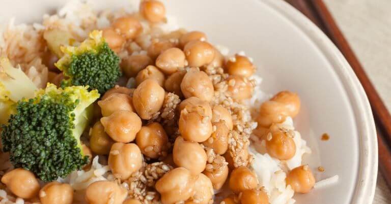 
Chickpeas and broccoli over rice with sesame seeds on top.